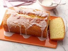 a loaf of pound cake with icing on an orange plate