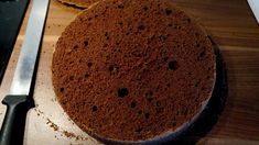 a cake sitting on top of a wooden table next to a knife