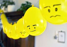 yellow balloons with faces hanging from strings