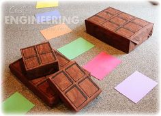 several pieces of wood sitting on the floor next to colored paper squares and sticky notes