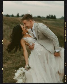 a man and woman are kissing in the grass