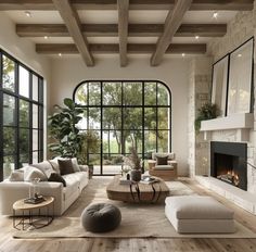 a living room filled with furniture and a fire place in front of a large window