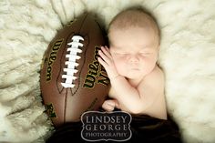 a baby is sleeping next to a football