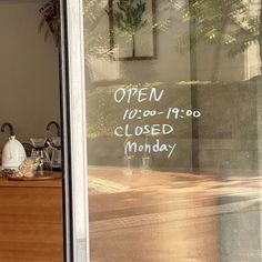 a closed window with writing on it in front of a wooden table and countertop