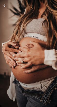 a pregnant woman is holding her stomach