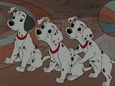 three dalmatian puppies sitting next to each other in front of a ball