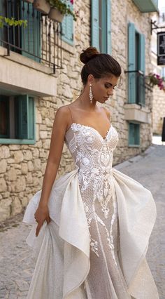 a woman in a wedding dress walking down the street