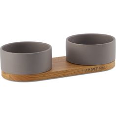 two grey bowls sitting on top of a wooden stand with the word labbenn