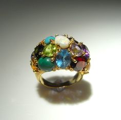 "Unique Birthstone Ring! Color POP! Magic Abstract Ring! Here we have a playful custom made natural multi-gemstone luxury bombe ring in 14K gold circa 1970. This dazzling colorful masterpiece was custom made and is one of a kind! The entire domed surface of this spectacular custom made ring is set with tutti frutti colored cabochon cut, round cut and oval cut natural gems. There are seventeen (17) in total! These include: natural earth mined untreated gems including natural green peridot, natura Unique Gold Rings, Handmade Gold Ring, Rainbow Rings, Ring Birthstone, Chunky Rings, Tutti Frutti, Handmade Rings, Green Peridot, Natural Opal