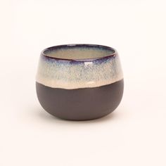 a blue and white bowl with black rim on a white background, it is made out of ceramic