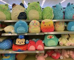 many stuffed animals are on shelves in a store