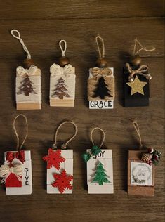 small christmas gift tags are hanging from twine strings on a wooden table with ornaments