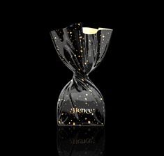 a glass bottle with gold flecks on the top and bottom, sitting in front of a black background