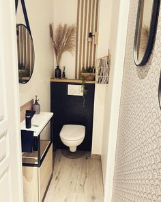 a white toilet sitting in a bathroom next to a wooden counter and wall mounted mirror