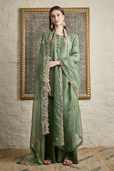 Hunted green silk kurta with front embellished buttons detailing. Paired with sharara and floral embroidered sheer dupatta.
Component: 3
Pattern: Embroidered
Type Of Work: Floral
Neckline: Round
Sleeve Type: Straight sleeves
Fabric: Silk,organza
Color: Green
Other Details: 
Front embellished buttons
Floral embroidered dupatta
Occasion: Mehendi - Aza Fashions Organza Kurta, Sheer Dupatta, Punjabi Suit Boutique, Maharani Designer Boutique, Embellished Buttons, Long Outerwear, Kurta Sharara Set, Kurta Sharara, Designer Punjabi Suits