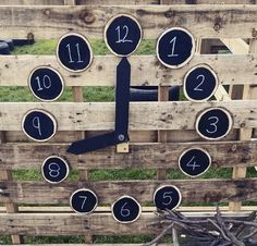 a clock made out of wooden pallets with numbers on the sides and around it