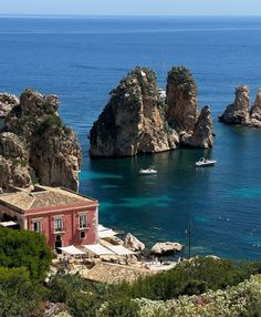 an island with many rocks and boats in the water