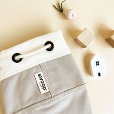 a white bag with black handles sitting on top of a table next to wooden blocks