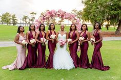 a group of women standing next to each other on top of a lush green field