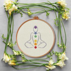 a cross stitch pattern with flowers surrounding it