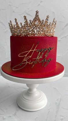 a red and gold birthday cake with a happy birthday crown on top that says happy birthday