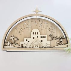 the nativity scene is made out of wood and features an arch that has been cut into