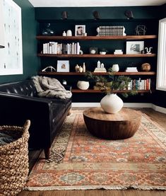 a living room filled with furniture and bookshelves next to a wall mounted book shelf