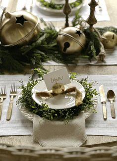 a place setting with silverware and greenery