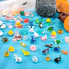 there are many small toy animals on the table together, including one fish and two seahorses