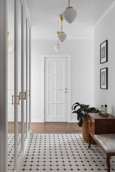 a hallway with white walls and black and white flooring