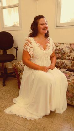 a woman in a white dress sitting on a couch