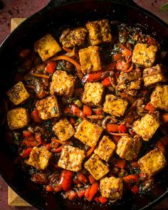 tofu and vegetables cooking in a skillet