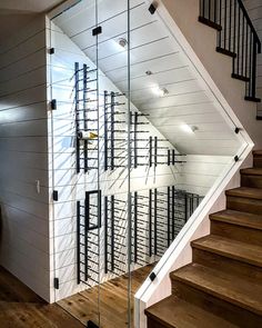 a stair case with wine racks on the wall and glass doors in front of it