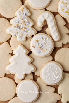 decorated cookies with white frosting and gold sprinkles are arranged on a table