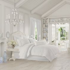 a bedroom with white furniture and chandelier hanging from the ceiling next to a fireplace