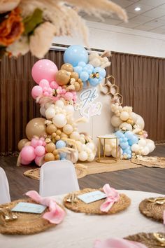 a table topped with lots of balloons and decorations