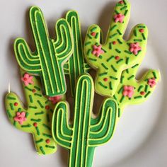 decorated cookies in the shape of cactuses on a plate