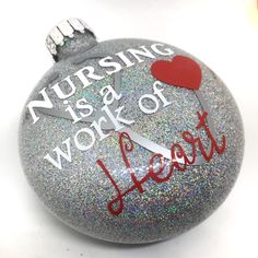 a christmas ornament with the words nursing is a work of heart on it