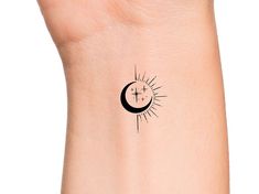 the sun and moon tattoo on the wrist is shown in black ink, with an arrow pointing