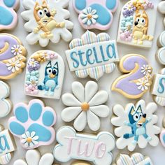 decorated cookies are arranged in the shape of flowers and paw patrol characters, with name tags on them