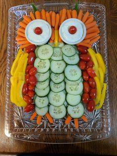 a clear plate topped with cucumbers, carrots and other veggies