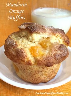 an orange muffin on a plate next to a glass of milk with the words mandarin orange muffins