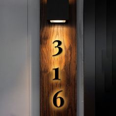 a wooden plaque with numbers on it in the shape of a number and two lights