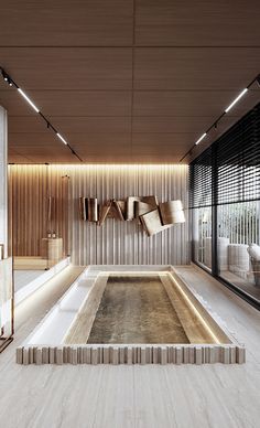 an indoor swimming pool in the middle of a room with wooden walls and flooring