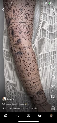 a woman's arm with tattoos on it and an image of flowers in the background