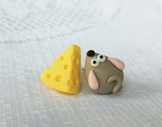 a small toy mouse next to a piece of cheese