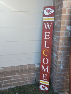 a wooden welcome sign sitting next to a brick building