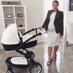 a woman standing next to a baby stroller in a room with tile flooring