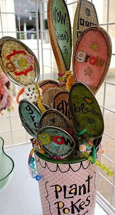 there are many spoons in the cup that is decorated with letters and numbers on it