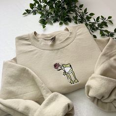 ✿ Flower Frog Embroidered Sweatshirt 🐸🌸 - ✿ Frog with flower embroidered on a unisex sweatshirt! an amazing gift idea!  - ✿ This design can be done on different coloured sweatshirts and with different coloured thread, as well as on totes, t-shirts and hoodies so please message me if you'd like to personalise it!  - ✿ Please look at the last slide for the size guide! I do not accept returns if you pick the wrong size, so please make sure you choose the correct one!  - ✿ I have lots of other ite